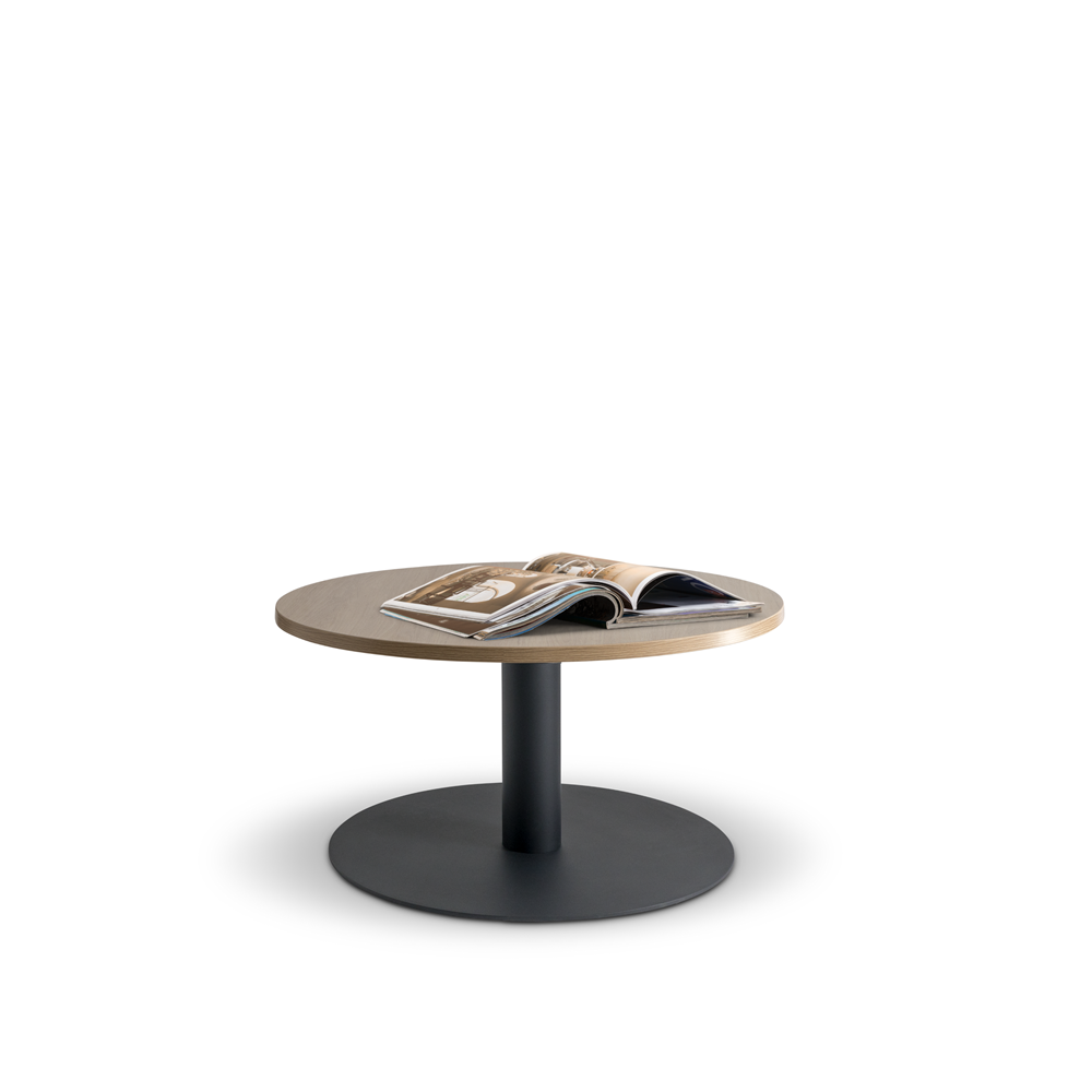 The Lunar 600 Coffee Table by Home Office Space NZ features a minimalist wooden round design with a black pedestal base, standing elegantly on a white background. An open magazine displaying images is laid out on the customizable and durable melamine top. The table's sleek design exudes contemporary style.